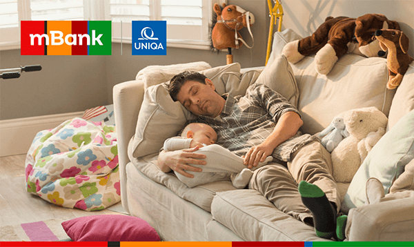 Kobieta z dwójką małych dzieci w łazience wkłada pranie do pralki. W lewym górnym rogu znajdują się logotypy mBank i UNIQA.